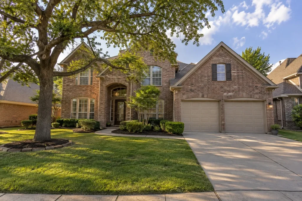 A brick home on a tree-lined North Texas street