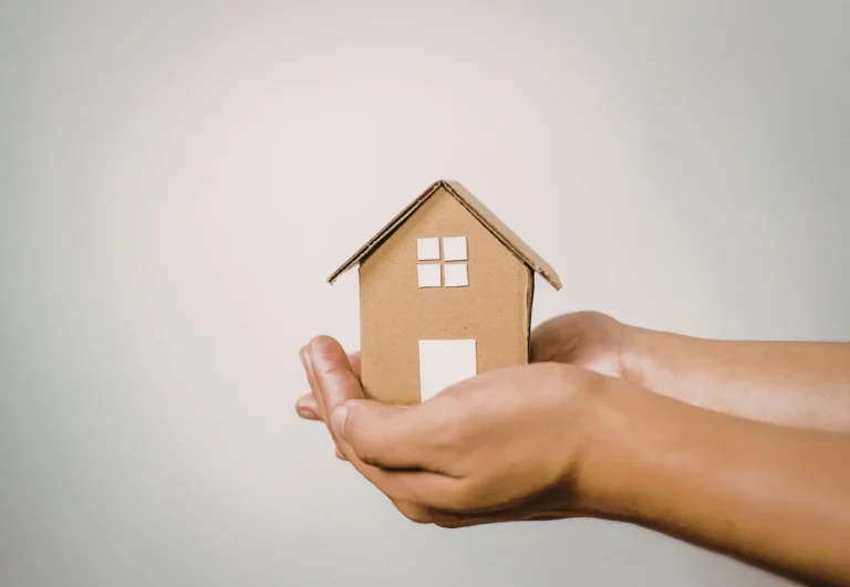 A small wooden house held in two hands — my free home seller guide