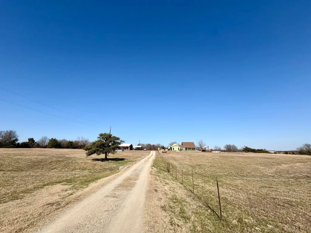 A county road and fence line along rural acreage in North Texas